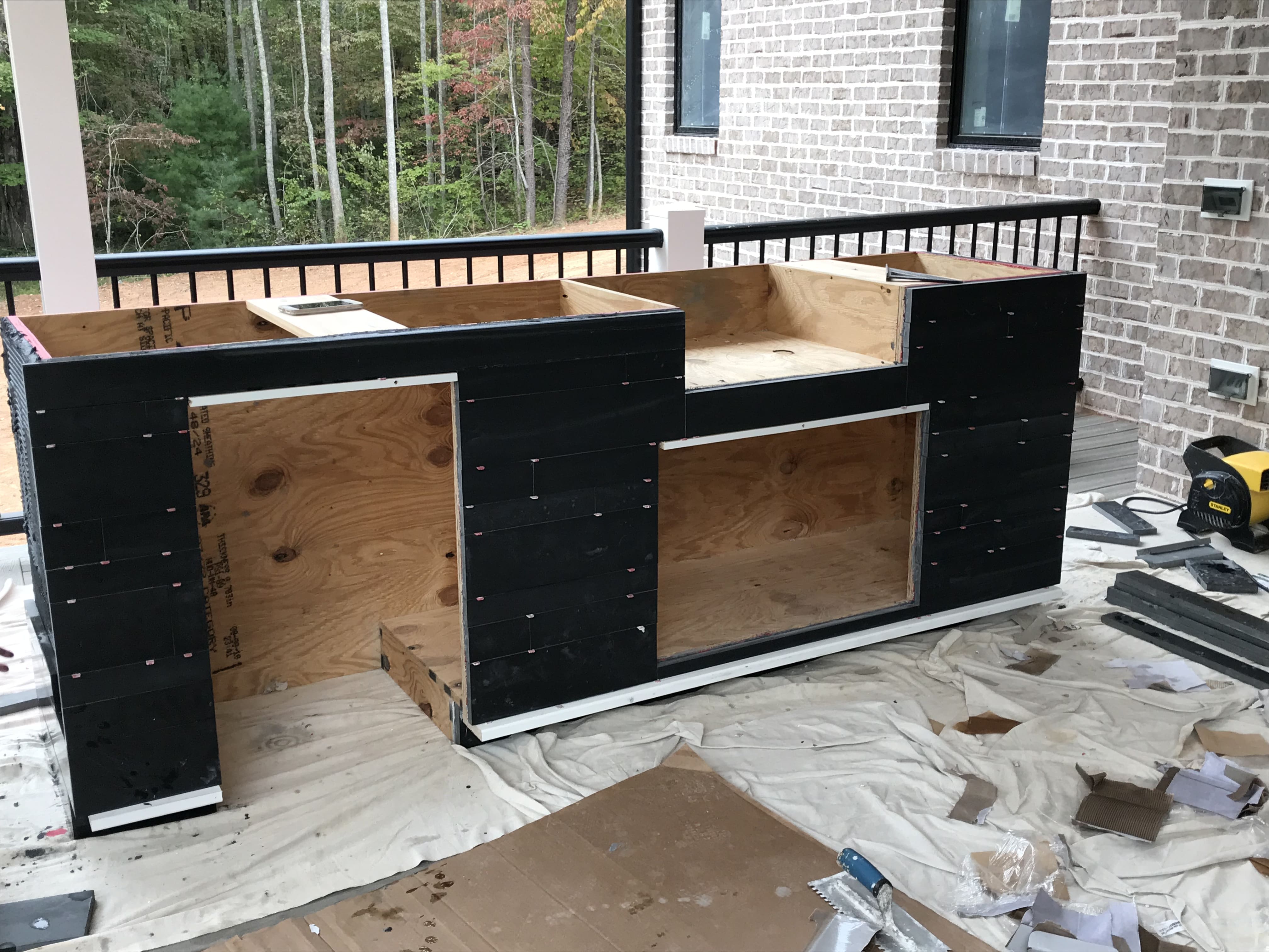 Norstone Ebony Planc Large Format Tile Being installated on a residential outdoor kitchen project